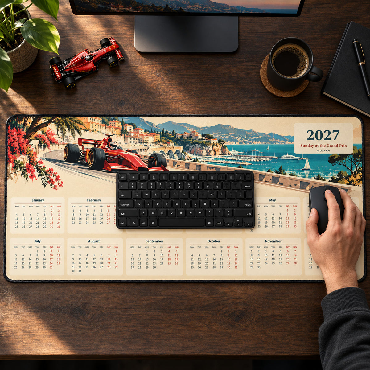 Riviera Racing Poster 2027 calendar desk pad in use with a computer mouse on a styled desk.